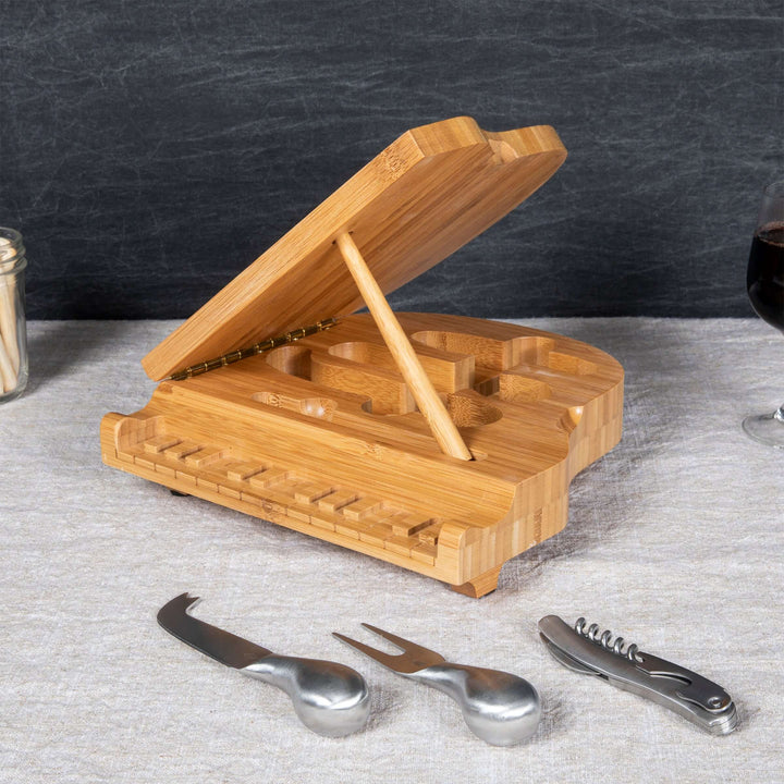Piano Cheese Board and Knife Set made of bamboo, designed to resemble a grand piano, with included cheese knives and corkscrew.