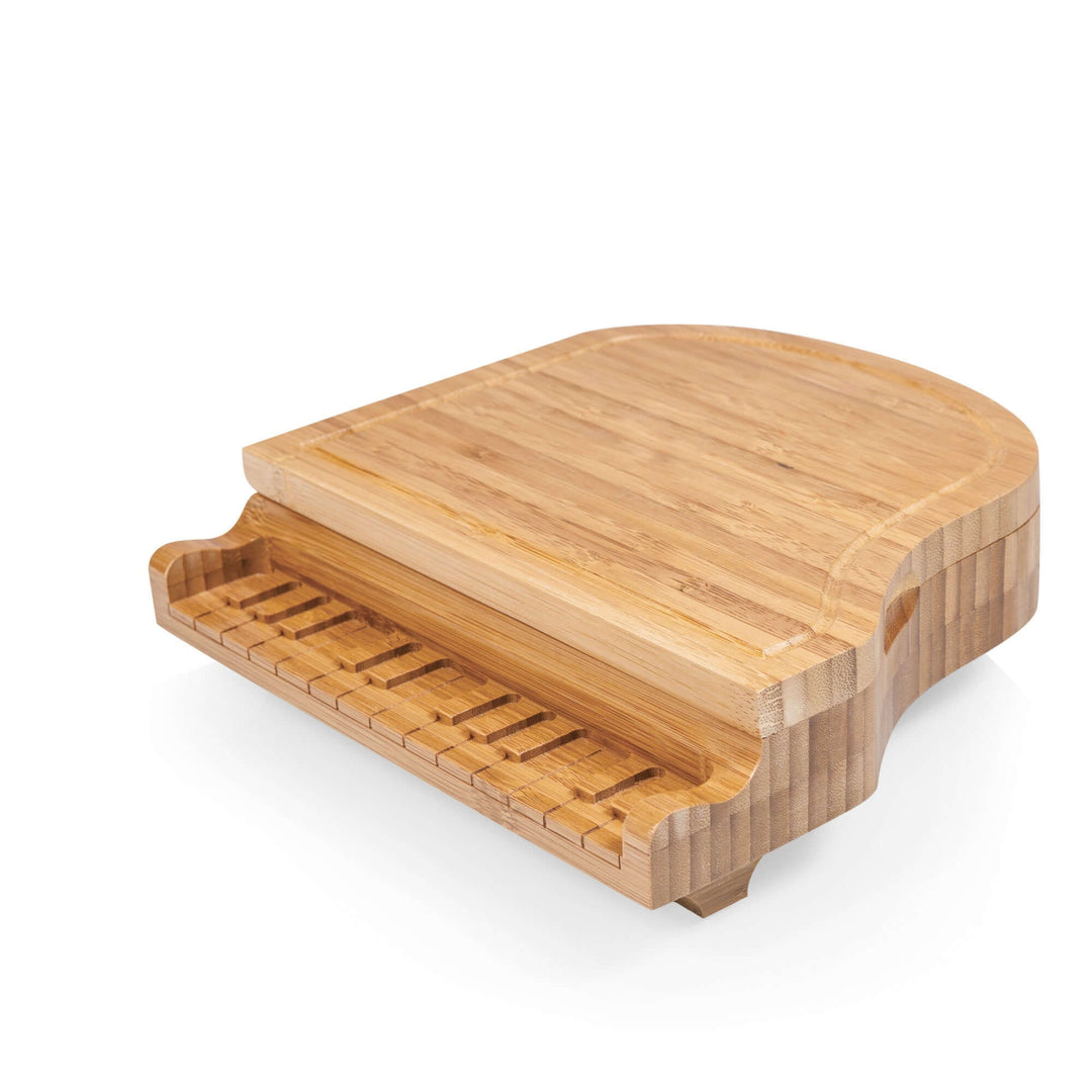 Wooden cheese board shaped like a grand piano on a white background
