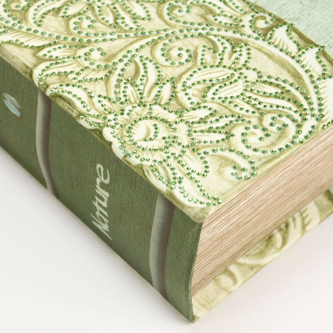 Green book with decorative green embellishments on a white background