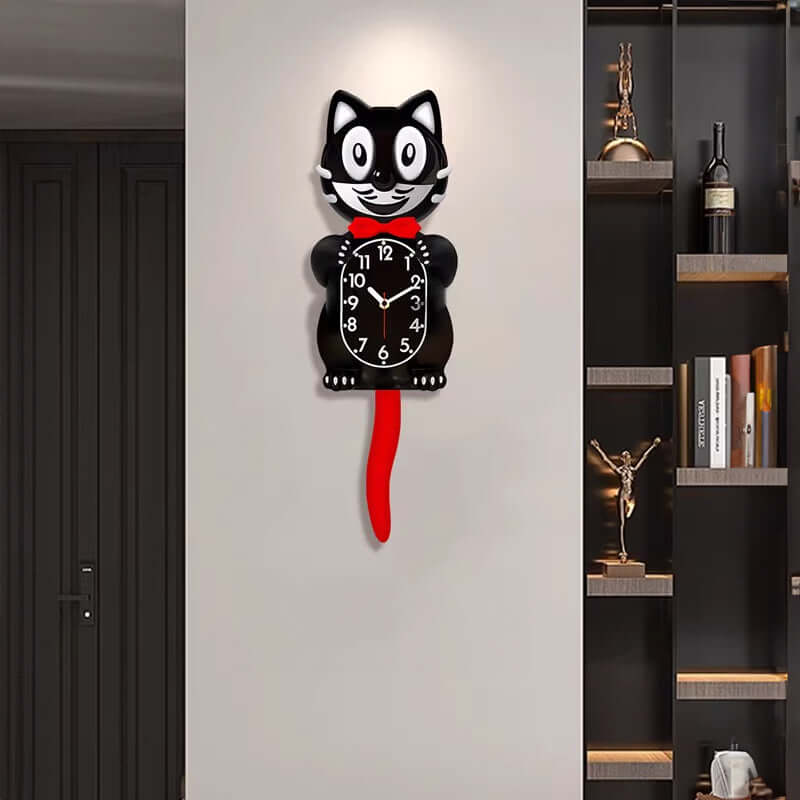 Cat-shaped wall clock with a red tail on a white wall next to a bookshelf.