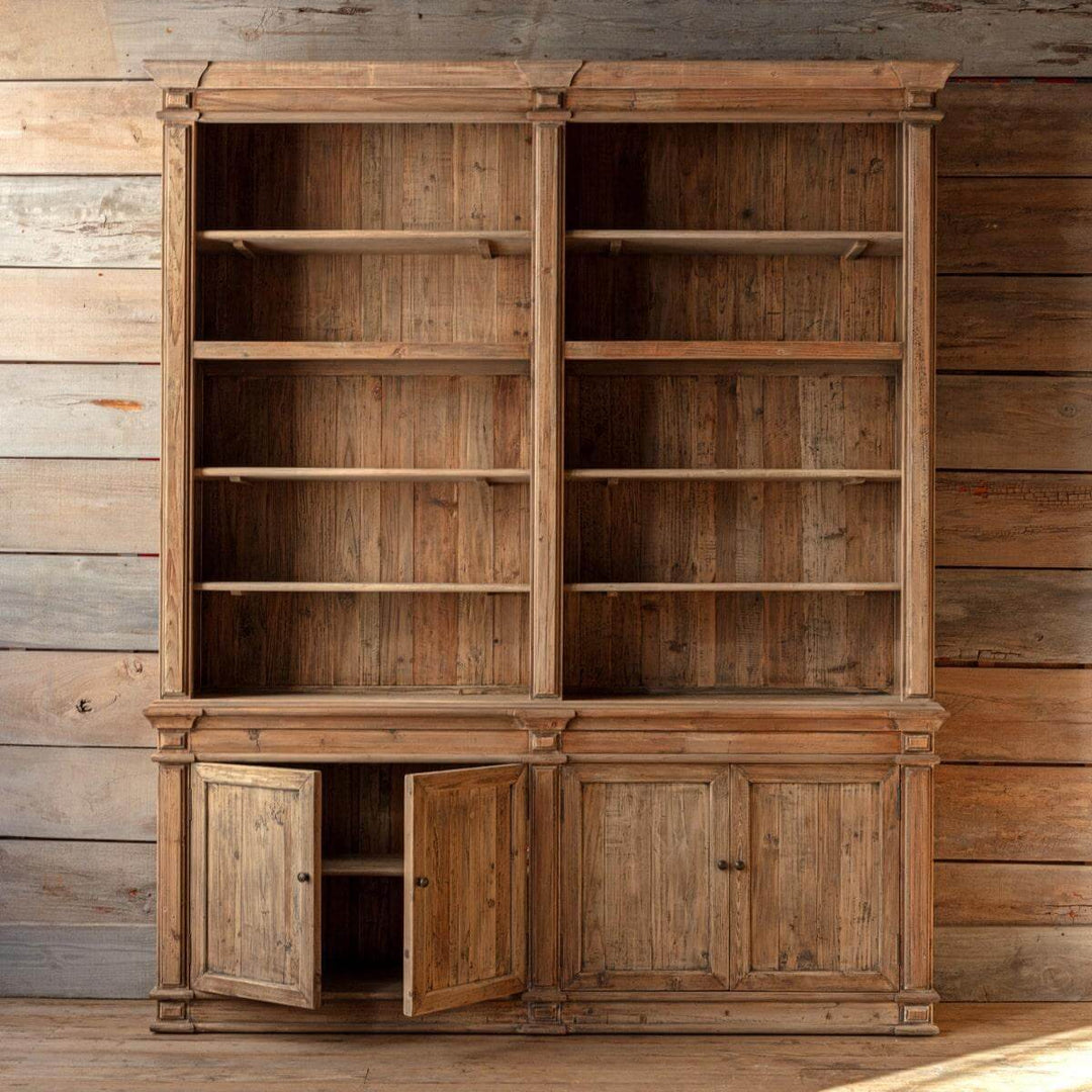 Wooden bookshelf with open doors against a wooden wall.