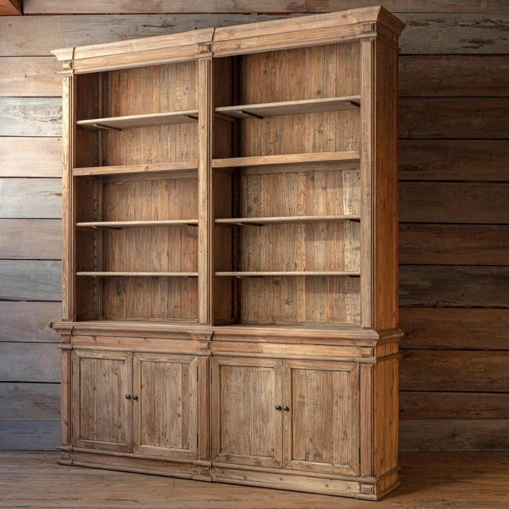 Wooden bookshelf with cabinets against a wooden wall.