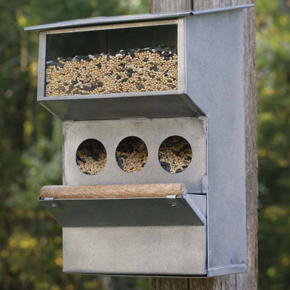 Rustic farmhouse bird feeder with multiple feeding holes for birds, made from sturdy galvanized metal.