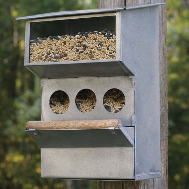 Rustic farmhouse bird feeder with multiple feeding holes for birds, made from sturdy galvanized metal.