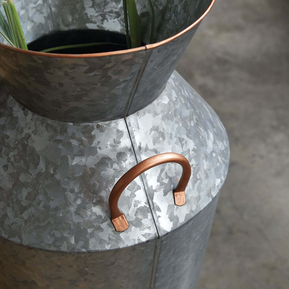 Rustic galvanized metal floor vase with copper handles and greenery, perfect for vintage home decor.