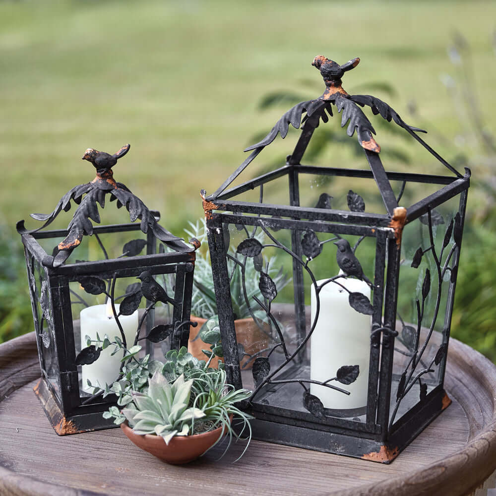 Set of two rustic woodland lanterns made of metal, featuring leaf designs, perfect for home decor.
