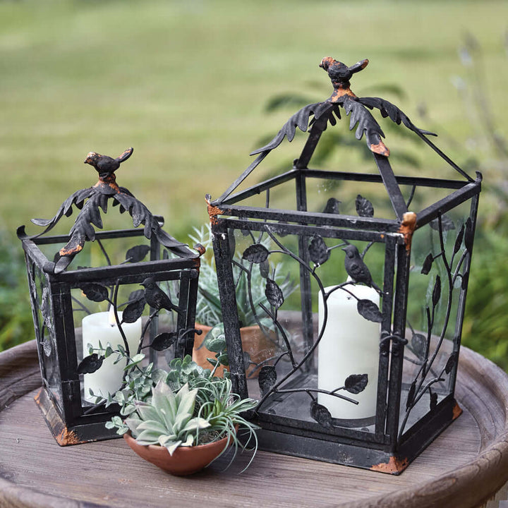 Set of two rustic woodland lanterns made of metal, featuring leaf designs, perfect for home decor.