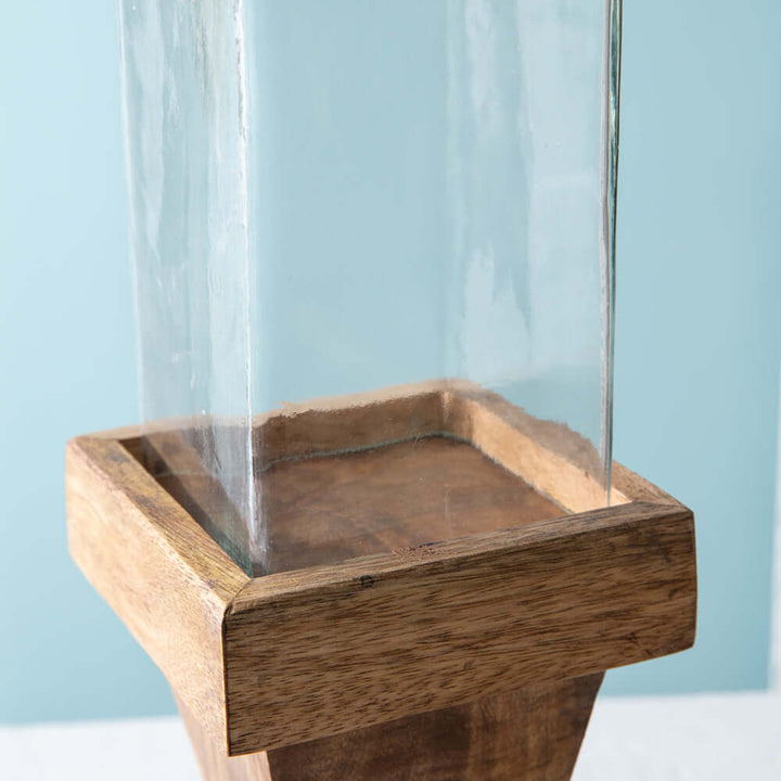 Close-up of rustic wood candle holder base with glass chimney, showcasing handcrafted detail and natural texture.