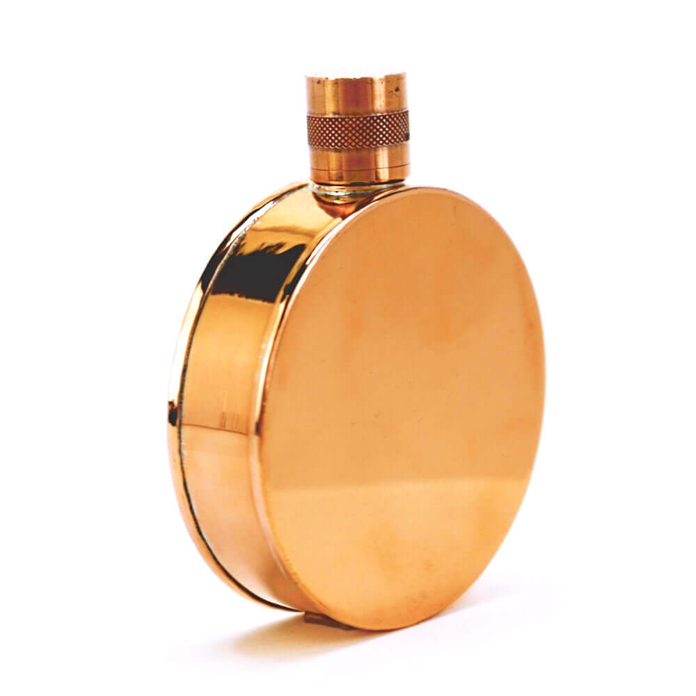 Copper round flask with a textured top on a white background