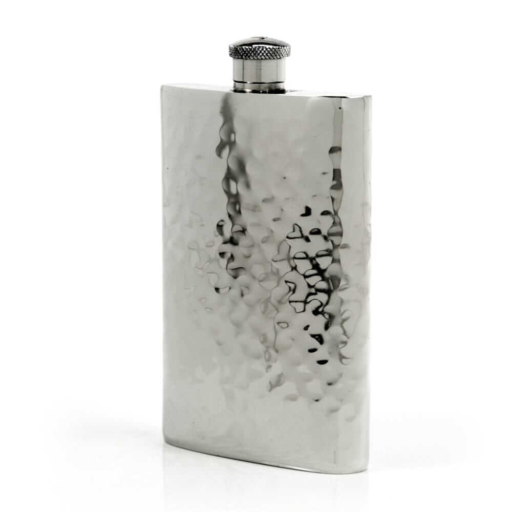 Pewter flask with textured surface on a white background