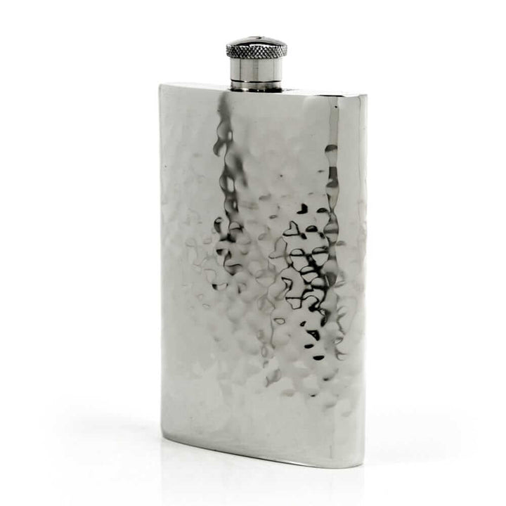 Pewter flask with textured surface on a white background