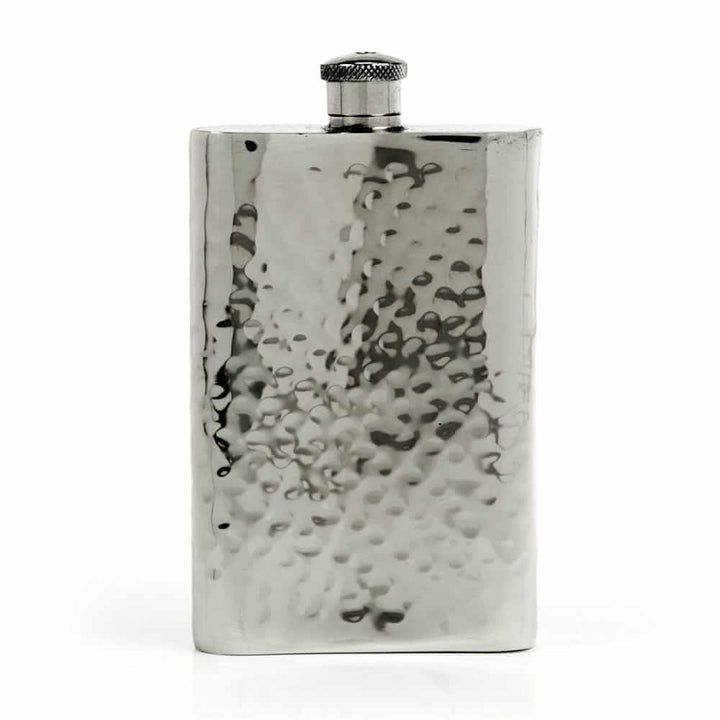 Pewter hip flask with textured surface on a white background