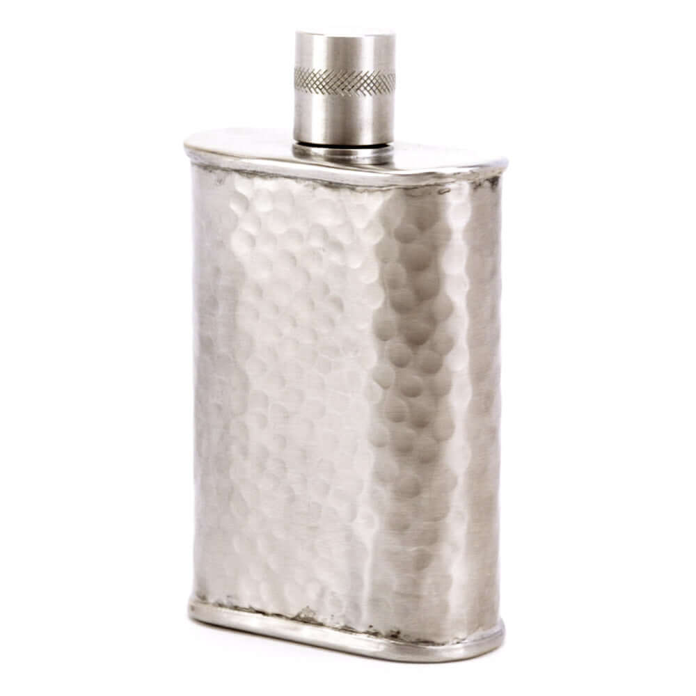 Silver hip flask with textured surface on a white background