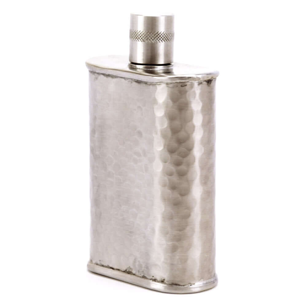 Silver hip flask with a textured surface on a white background