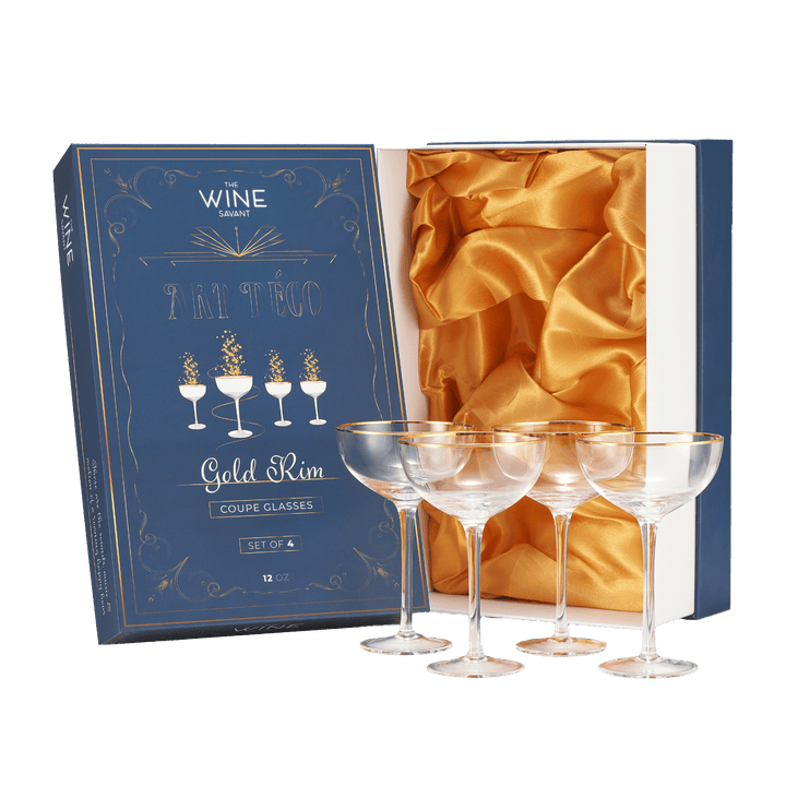 Set of four gold-rimmed wine glasses in a decorative box with gold interior.