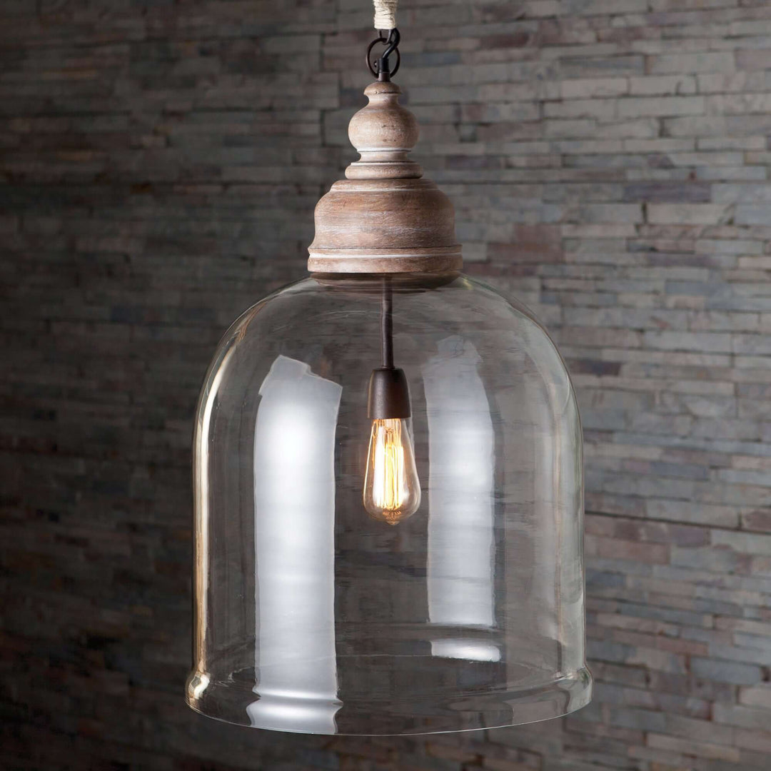 Farmhouse glass cloche pendant light with rustic wood accent, featuring a clear bell-shaped shade and warm bulb.
