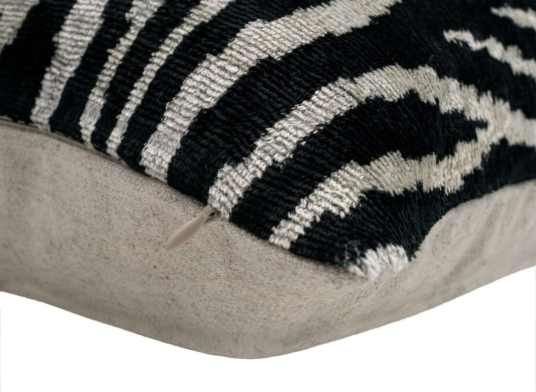 Close-up of a zebra-patterned cushion with a beige border on a white background