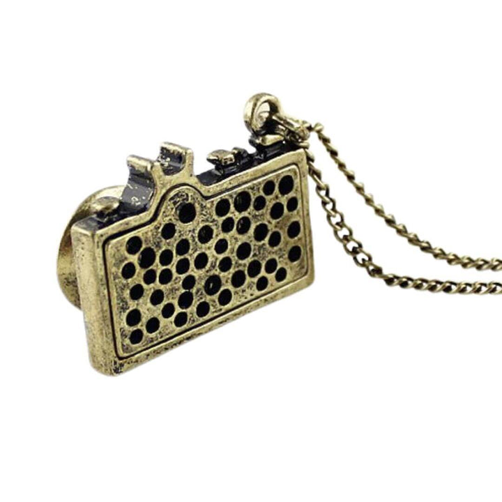 Vintage Camera Pendant Necklace with antique brass finish and teal enamel, featuring a crystal lens, exuding nostalgic charm in jewelry.