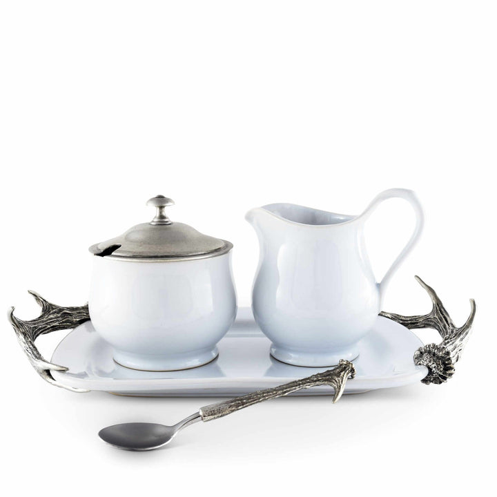 White ceramic sugar bowl, creamer, and tray with silver accents on a white background