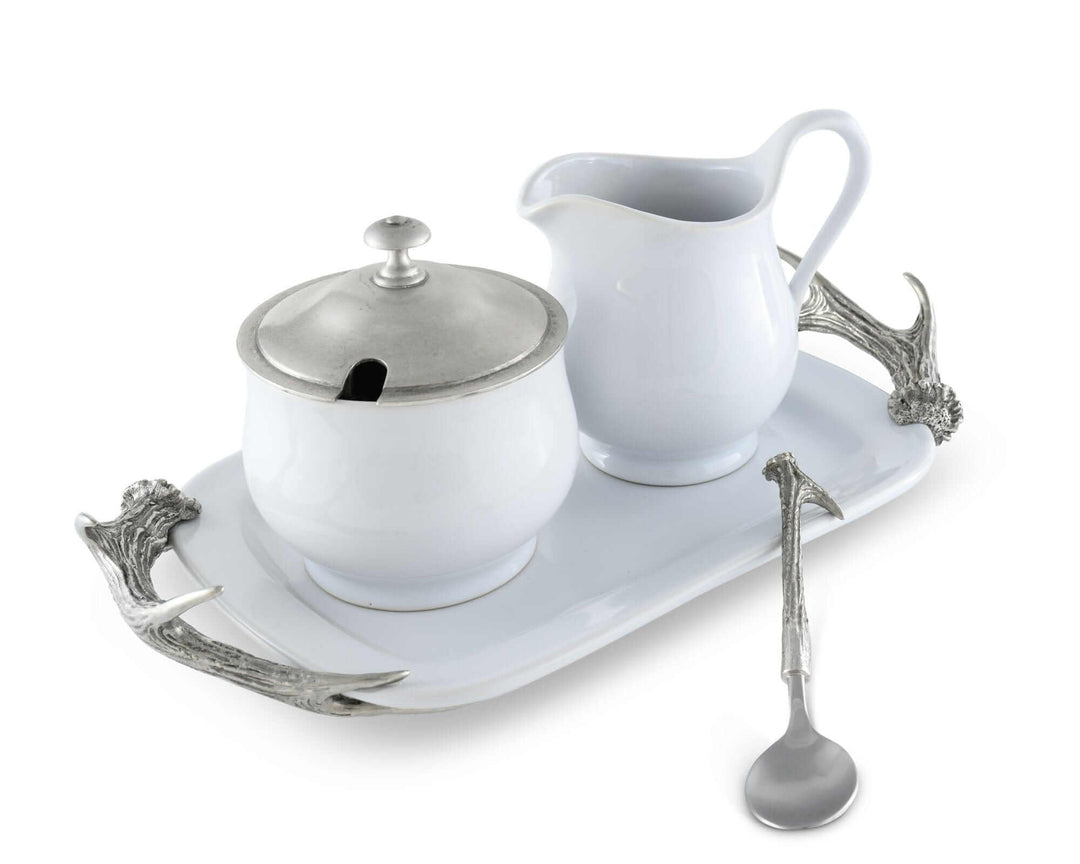 White ceramic sugar bowl, creamer, and tray with silver accents on a white background