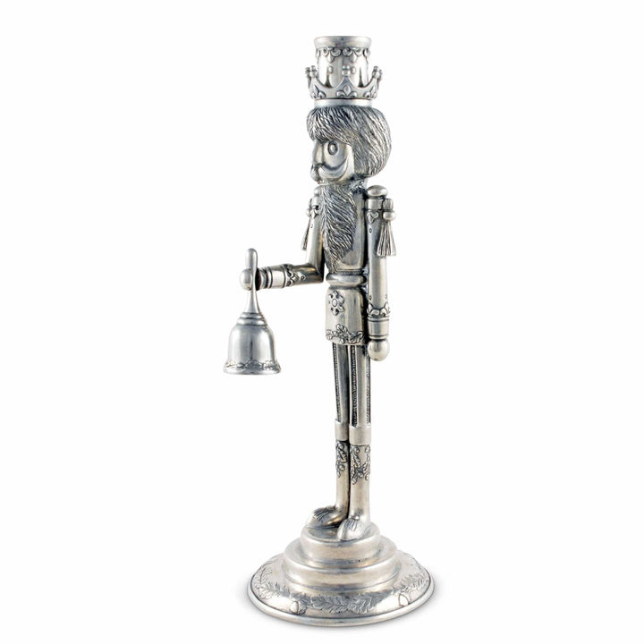 Silver nutcracker figurine with a crown and holding a bell on a white background