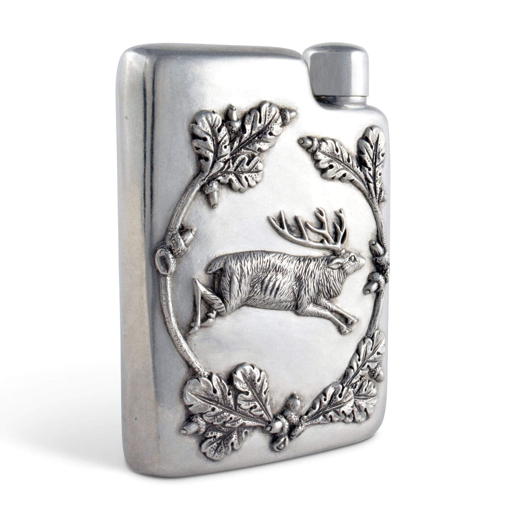 Silver flask with deer and leaf design on a white background