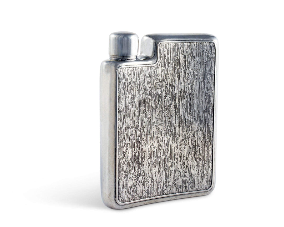 Silver textured hip flask on a white background