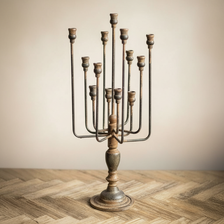 metal candelabra on a wooden floor with a beige wall background