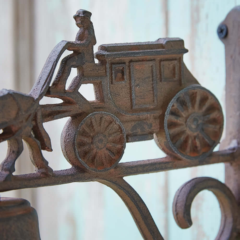 Vintage cast iron horse and stagecoach door bell close-up, showcasing detailed craftsmanship and nostalgic design.