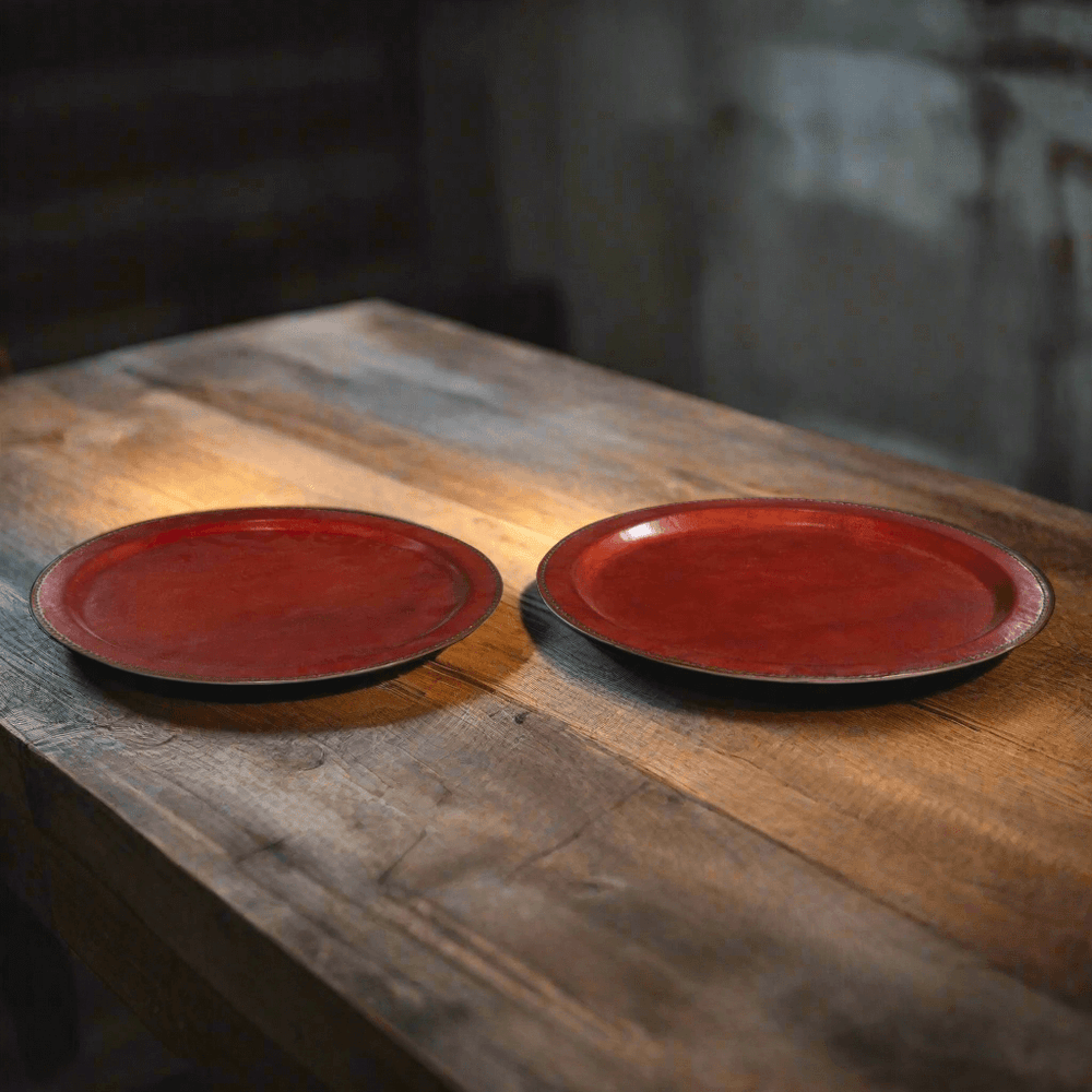 Two red leather trays on a wooden surface with a blurred background