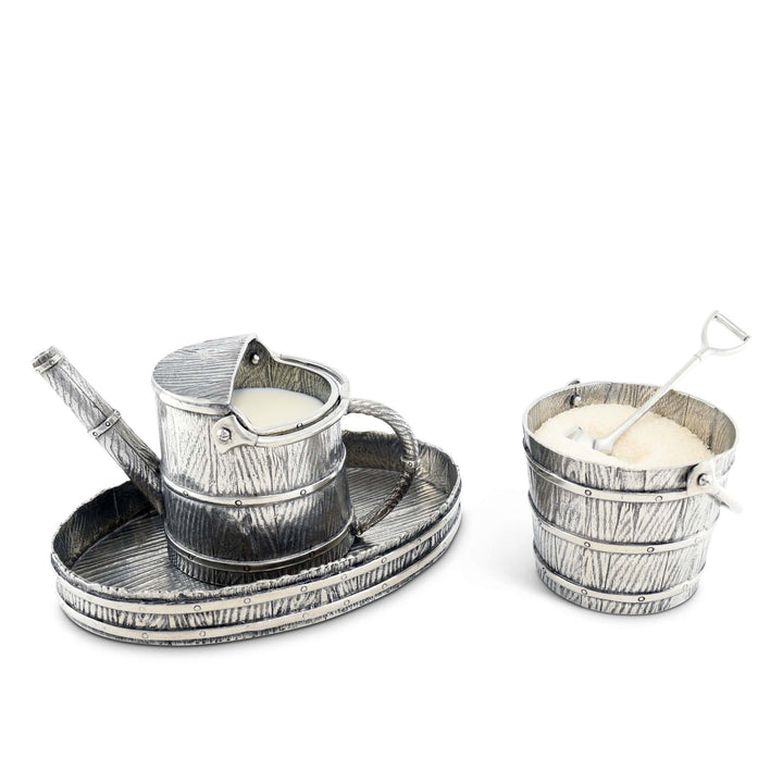 Decorative pewter creamer set on a white background