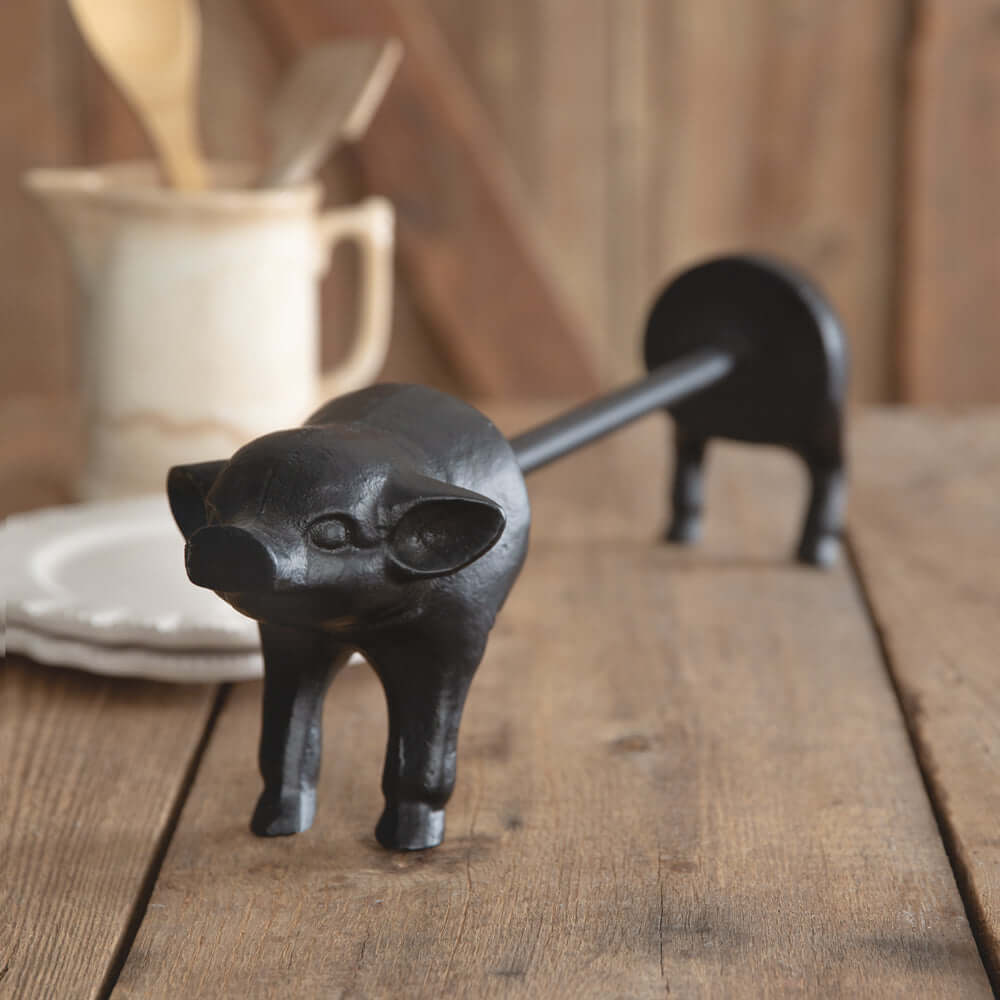 Vintage farmhouse pig paper towel holder, black cast iron kitchen accessory, adds rustic charm to home decor.