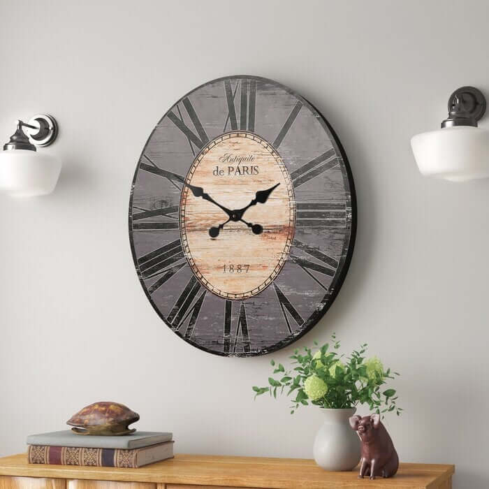 Decorative wall clock with wooden face and metal rim on a wall above a wooden console table.