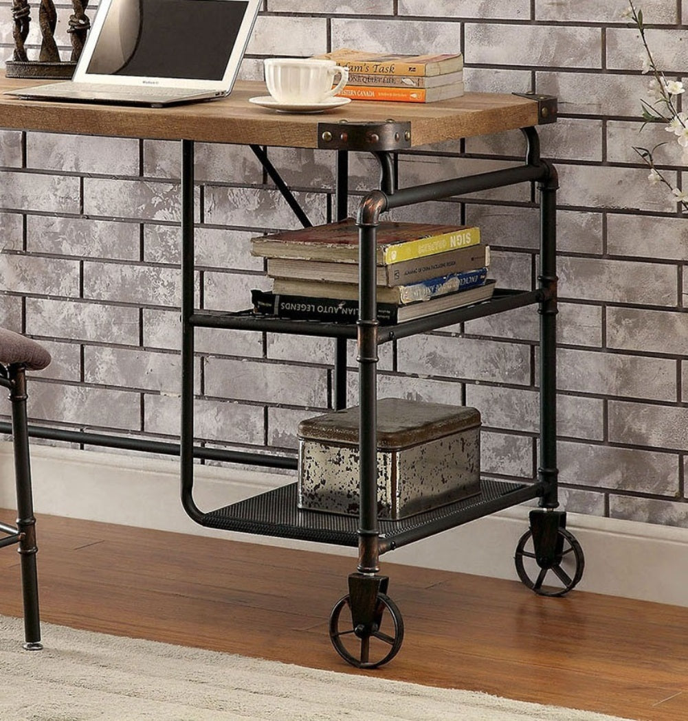 Industrial-style desk with books and a laptop against a brick wall.