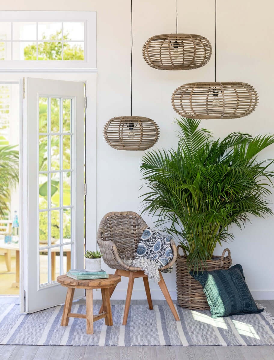 Living room with wicker chair, ottoman, and hanging rattan lamps.