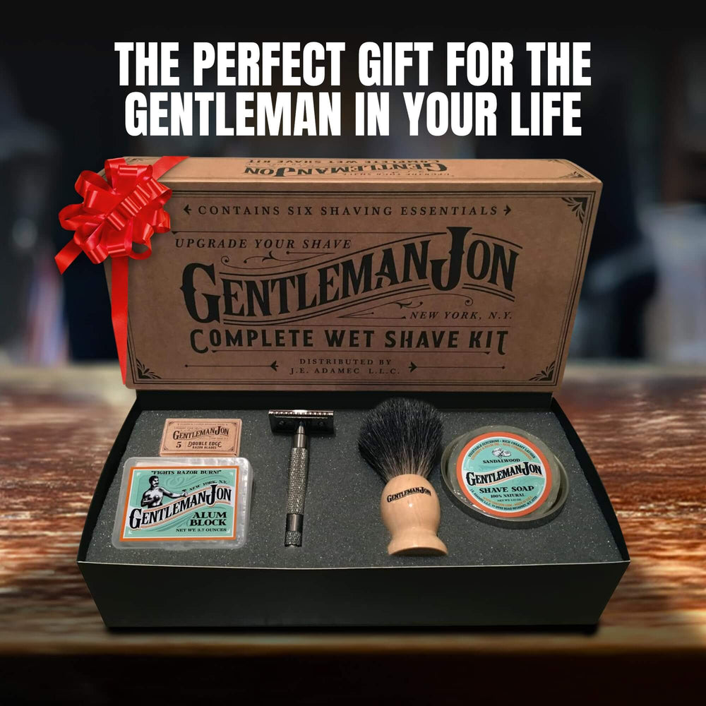 Gentleman Jon complete wet shave kit with a red bow on a wooden surface.