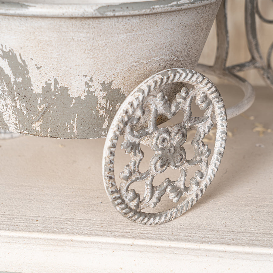 Decorative metal wheel with intricate design on a wooden surface
