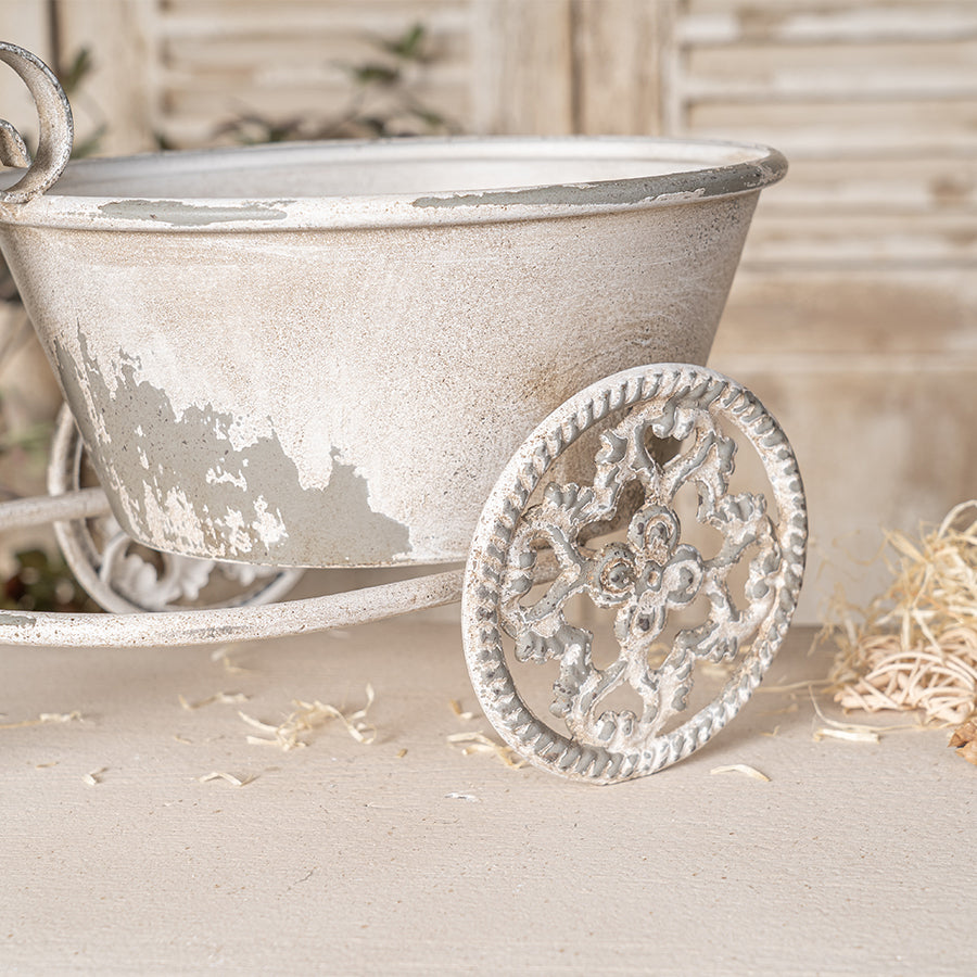 Vintage-style metal tricycle planter on a neutral background