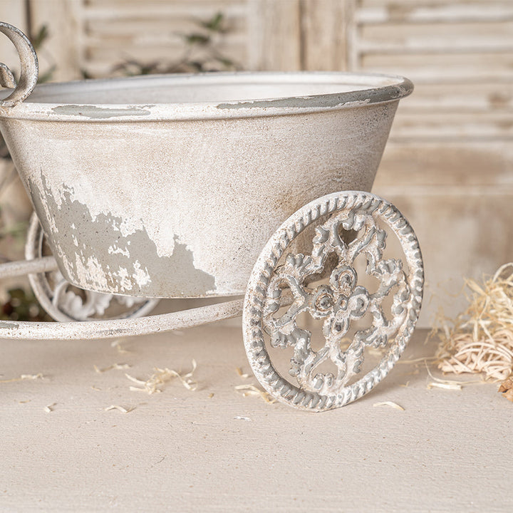Vintage-style metal tricycle planter on a neutral background