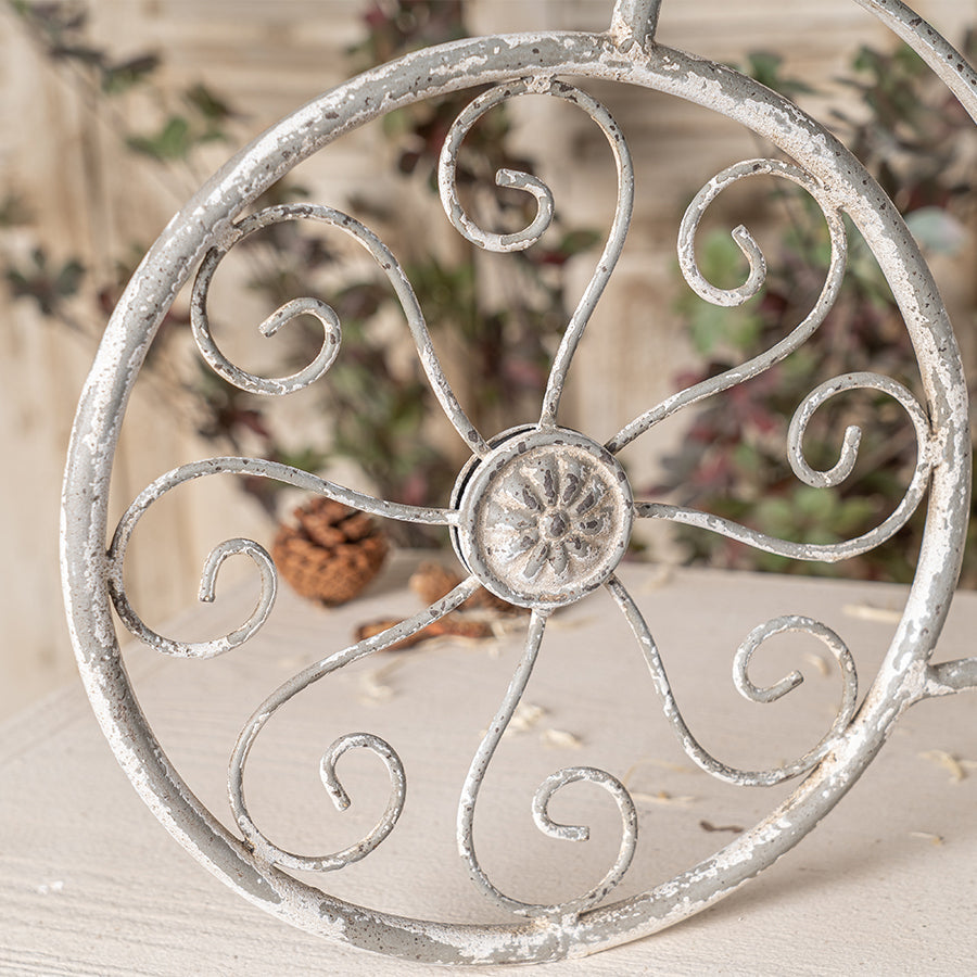 Decorative metal wheel with intricate designs on a neutral background