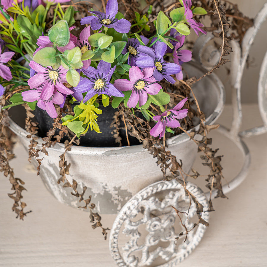 Decorative tricycle planter with artificial flowers and greenery