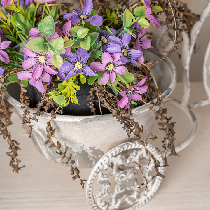 Decorative tricycle planter with artificial flowers and greenery