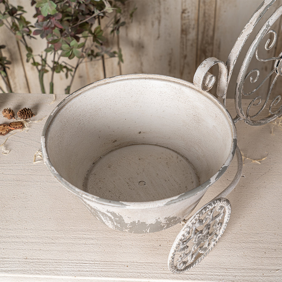 Vintage-style metal planter on a wooden surface with decorative elements.