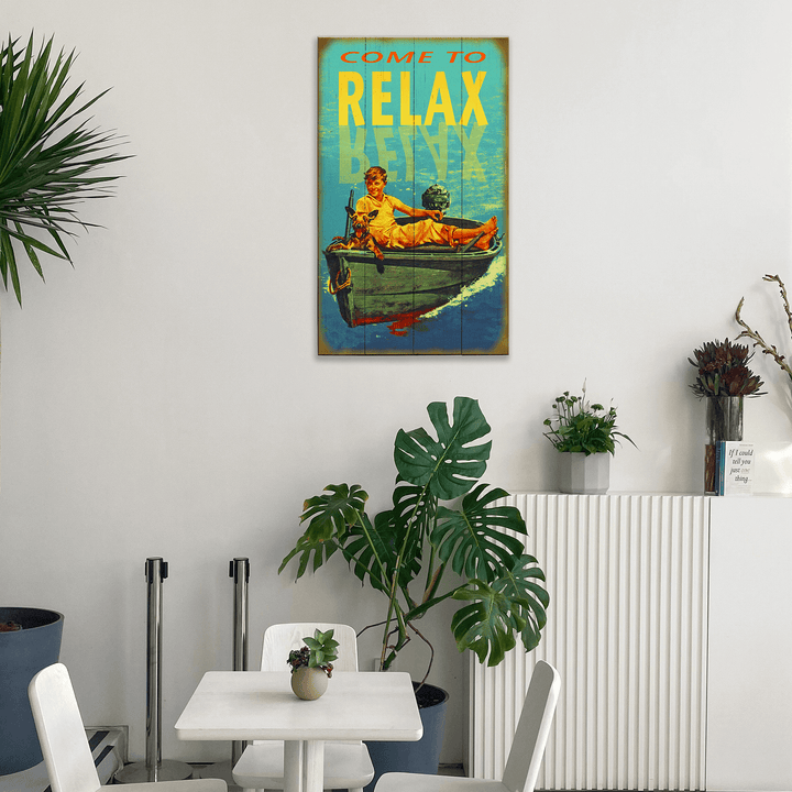 Decorative poster with a boy in a boat on a wall above a table with plants.
