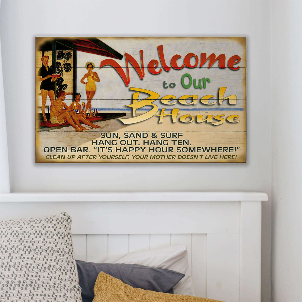 Decorative sign with beach-themed text and graphics on a wall above a bed.