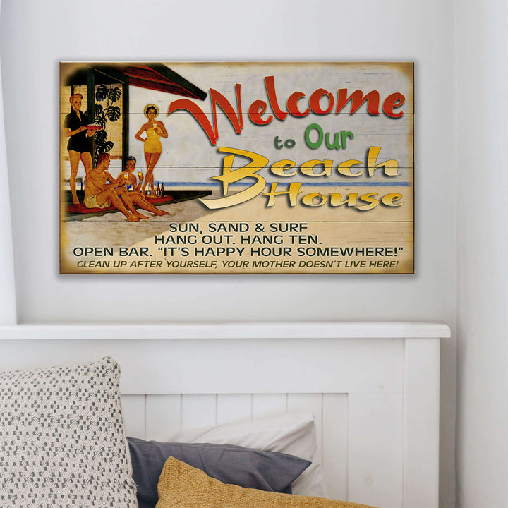 Decorative sign with beach-themed text and graphics on a wall above a bed.