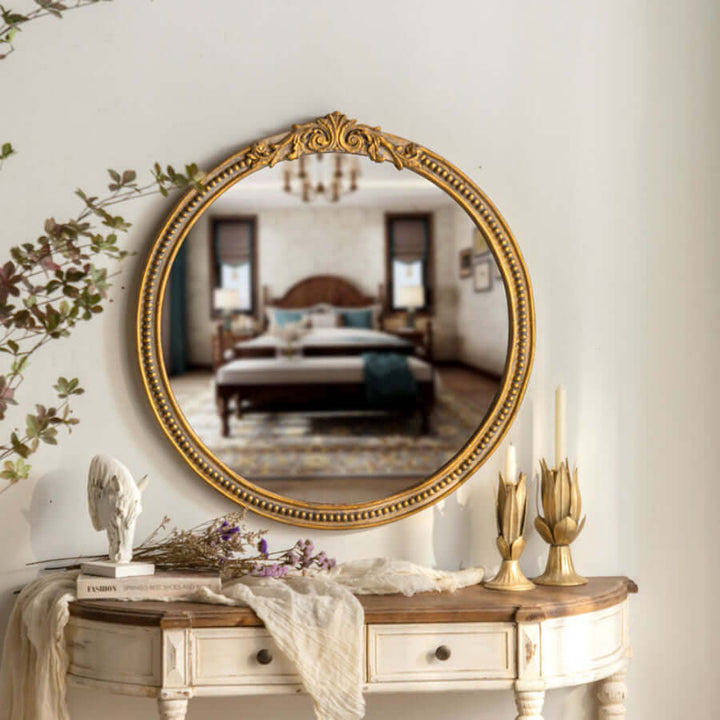 Vintage round gold wall mirror with ornate carved wood frame and classic European scrollwork