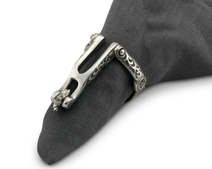 Silver spur napkin ring on a gray napkin against a white background