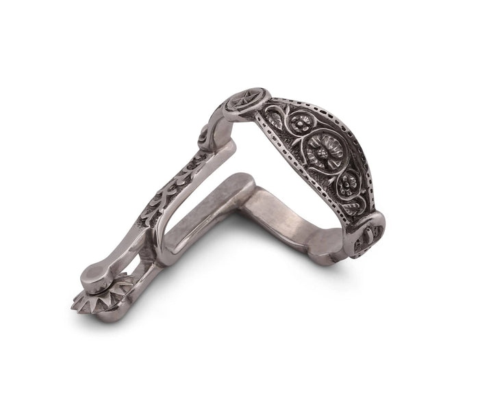 Decorative silver spur napkin ring with intricate designs on a white background