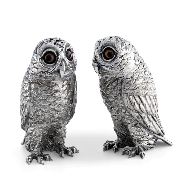 Two silver owl figurines on a white background